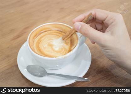 Hand On Hot Cup Of Coffee Latte, stock photo