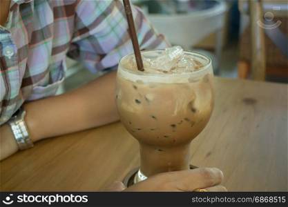 Hand on iced milk coffee, stock photo
