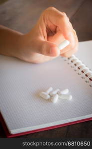 Hand on white pill medicine, stock photo