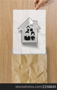 hand open crumpled paper to show hand draw family and house icon on wooden poster as insurance concept