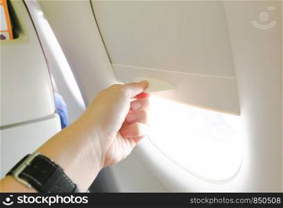 Hand Open the airplane window.