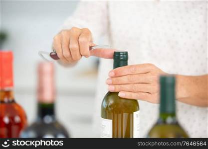 hand opening bottles of wine
