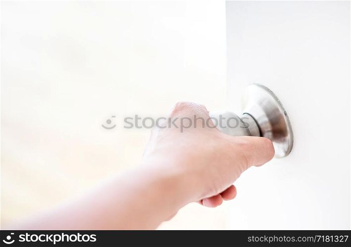 Hand opening door knob-white door.