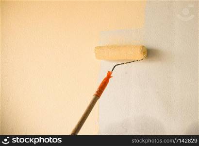 Hand painting wall background with paint roller on building construction site interior decoration