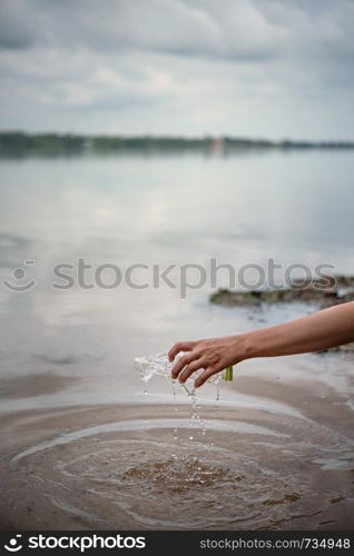 hand pick up plastic bottle from water. save environment and beat plastic pollution , Selective focus. hand pick up plastic bottle from water