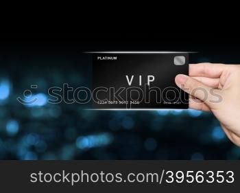 hand picking VIP or very important person platinum card on blur background