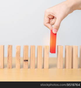 hand placing or pulling Red domino wooden block on table. Business planning, Risk Management, Solution, leader, strategy, different, Hiring, Human Resource and Unique Concepts