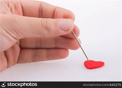 Hand pointing a needle on a heart