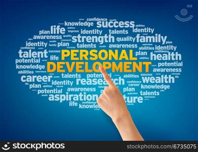 Hand pointing at a Personal Development Word Cloud on blue background.