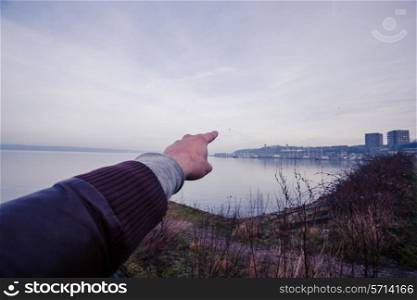 hand pointing at stuff by the sea