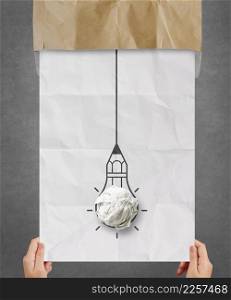 hand pulling light bulb crumpled paper out of recycle envelope as creative concept
