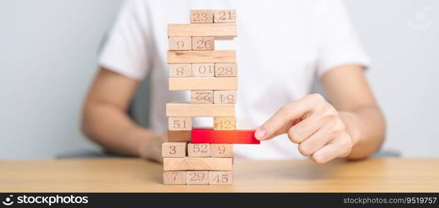 hand pulling wooden block tower on table. Business planning, Risk Management, Solution, leader, strategy, Crisis, falling Business, and Economic recession concept