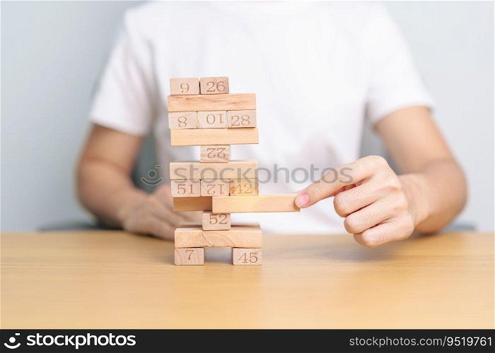 hand pulling wooden block tower on table. Business planning, Risk Management, Solution, leader, strategy, Crisis, falling Business, and Economic recession concept