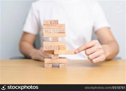 hand pulling wooden block tower on table. Business planning, Risk Management, Solution, leader, strategy, Crisis, falling Business, and Economic recession concept