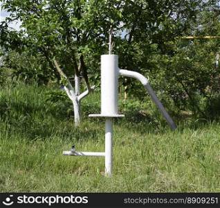 Hand pump leading to an artesian well. Pumping water for watering the garden.. Hand pump leading to an artesian well.