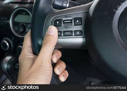 hand pushes the cruise control button on a steering