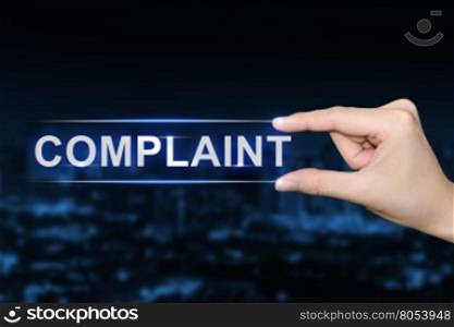 hand pushing complaint button on blurred blue background