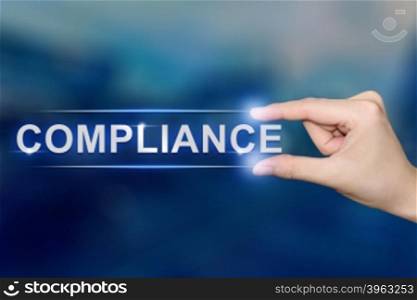 hand pushing compliance button on blurred blue background