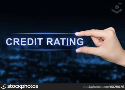 hand pushing credit rating button on blurred blue background
