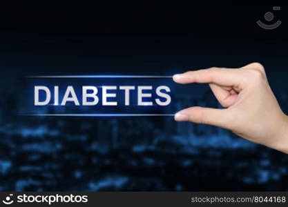 hand pushing diabetes button on blurred blue background