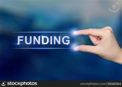 hand pushing funding button on blurred blue background