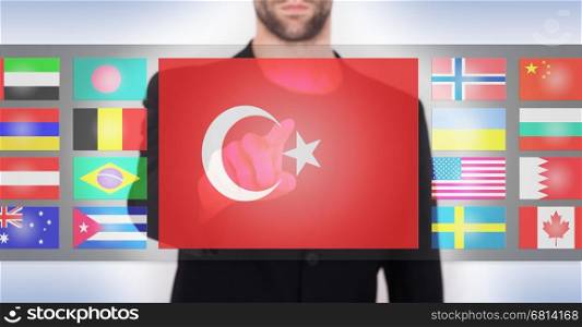 Hand pushing on a touch screen interface, choosing language or country, Turkey