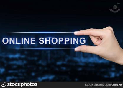 hand pushing online shopping button on blurred blue background