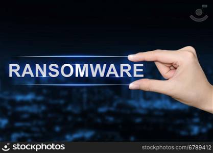 hand pushing ransomware button on blurred blue background