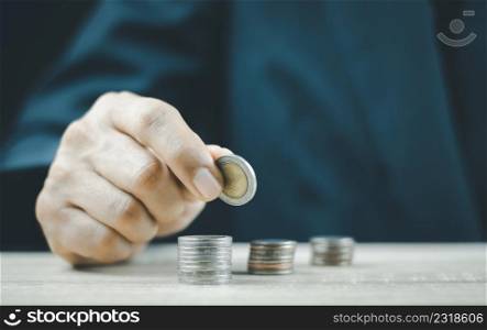 Hand put coins to stack of coins,Savings money and income or Investment Ideas and Financial Management for the Future