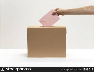 hand puts pink envelope into vote box. Resolution and high quality beautiful photo. hand puts pink envelope into vote box. High quality beautiful photo concept