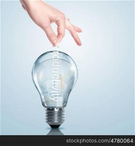 Hand putting a busines term into a light bulb