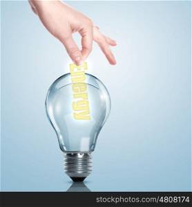 Hand putting a busines term into a light bulb