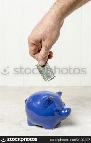 hand putting bank note piggy bank