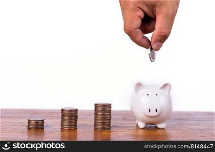 Hand putting coin to piggy bank with stack coin. Saving money and investment concept. Save money.