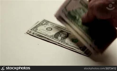 Hand putting dollar bills on table close-up