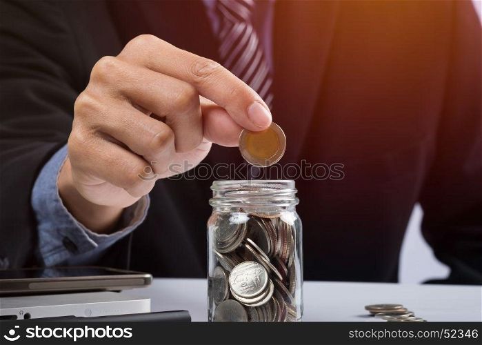 Hand putting mix coins and seed in clear bottle and copyspace, Business investment growth concept.