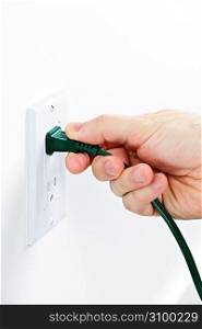 Hand removing plug from outlet