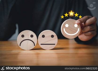 Hand selecting a smiley face icon on a wood block circle, indicating best service rating. Satisfaction survey concept with 5-star satisfaction.