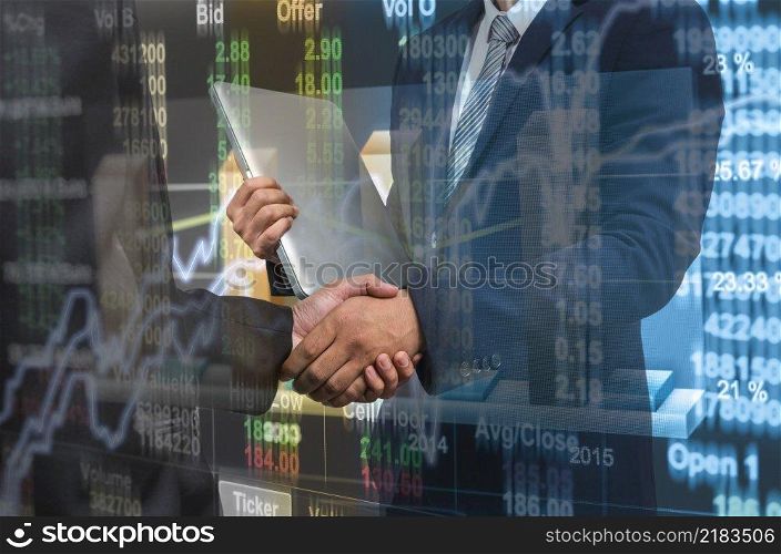 Hand shake between businessman over Stock market chart,Closeup Stock market exchange data on LED display, business trading concept