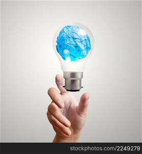 hand showing light bulb with crumpled paper as creative concept
