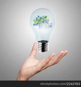 hand showing light bulb with gears as concept