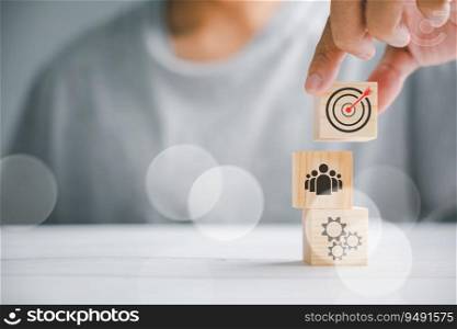 Hand skillfully arranging wooden blocks, representing the business strategy and action plan. Targeting the concept of business development. Copy space is available.