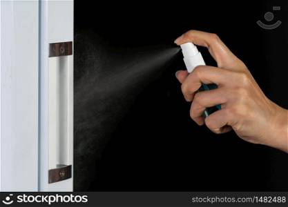 hand spraying alcohol to cleaning door knob for protect from infection of virus and germ Covid-19 coronavirus