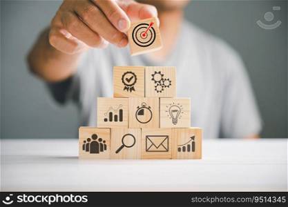 Hand stacking wooden blocks on a table, emphasizing the significance of a business strategy and action plan. Business development concept with copy space for customization.