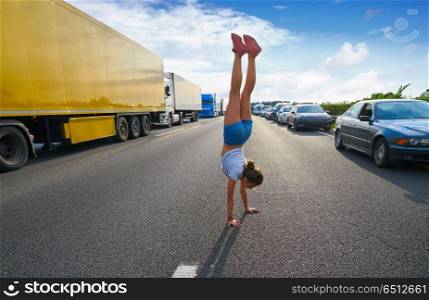 Hand stand girl in a traffic jam road. Acrobatic hand stand girl in a traffic jam road having fun