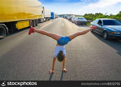 Hand stand girl in a traffic jam road. Acrobatic hand stand girl in a traffic jam road having fun