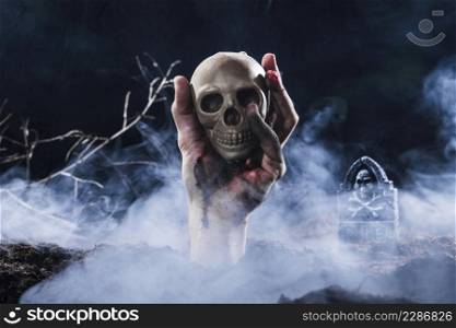 hand sticking out ground holding skull