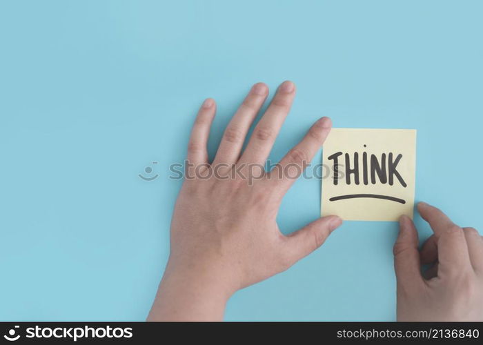 hand sticking think adhesive note blue background