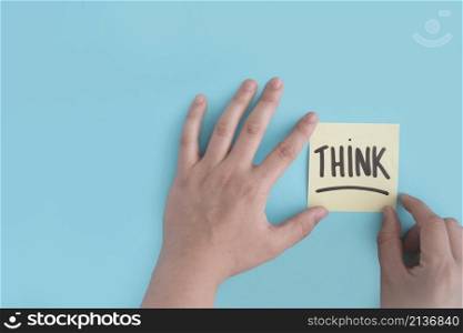 hand sticking think adhesive note blue background