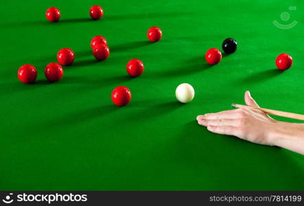 Hand, supporting a cue stick on a snooker table
